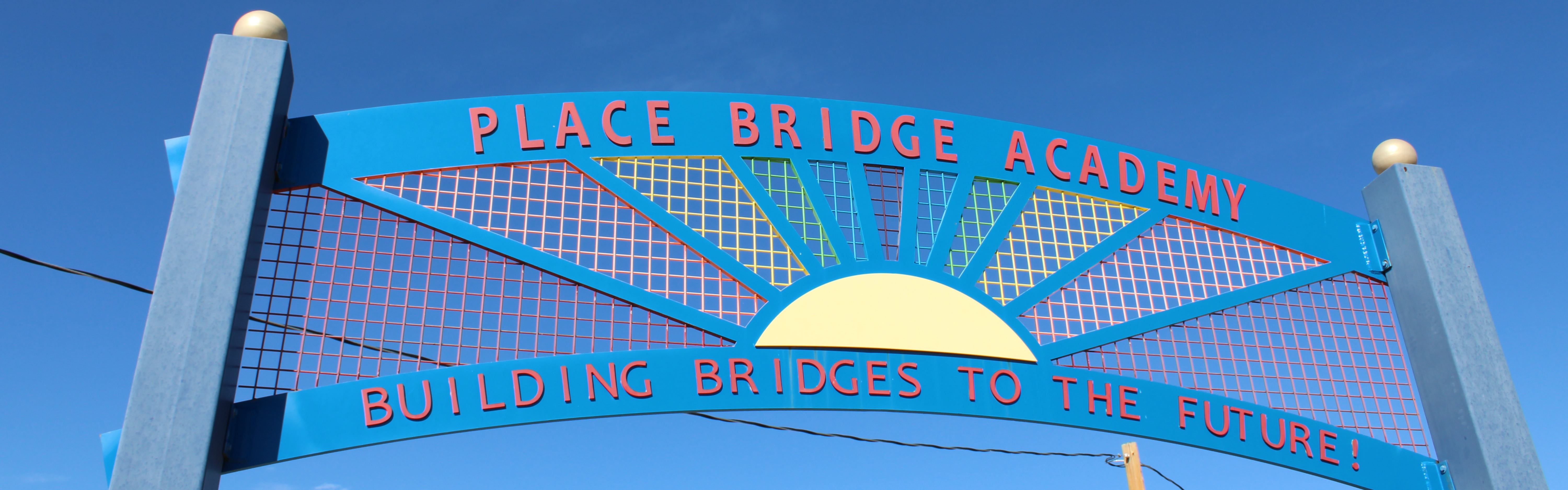 A blue sign reads "Place Bridge Academy" with a sun graphic and "Building Bridges to the Future" below.