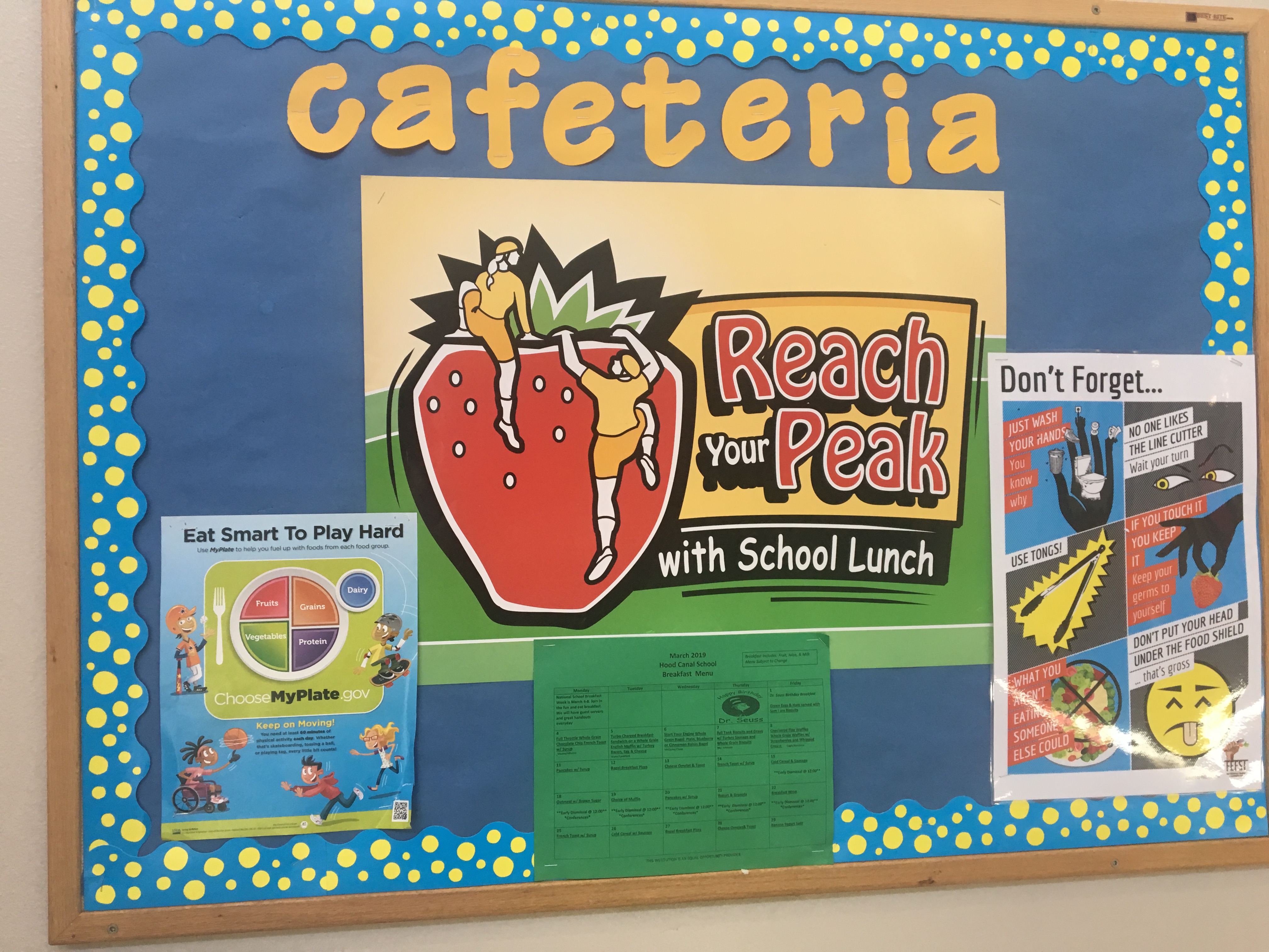 cafeteria bulletin board with reach your peak written on it