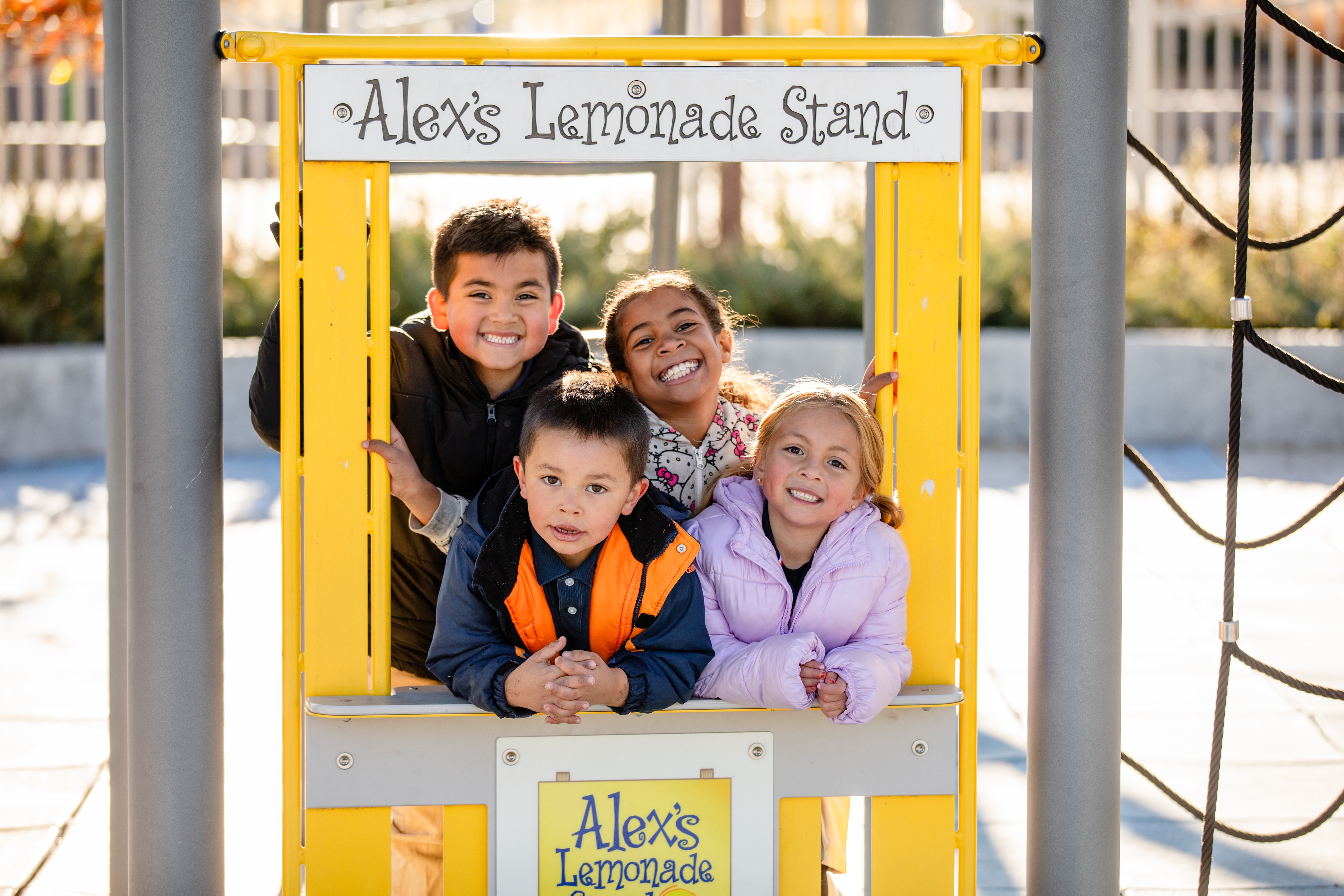 A group of students pose for a picture on the playground.