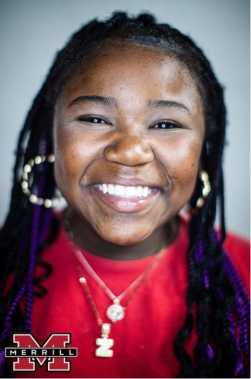 A Black Merrill student smiles at the camera.