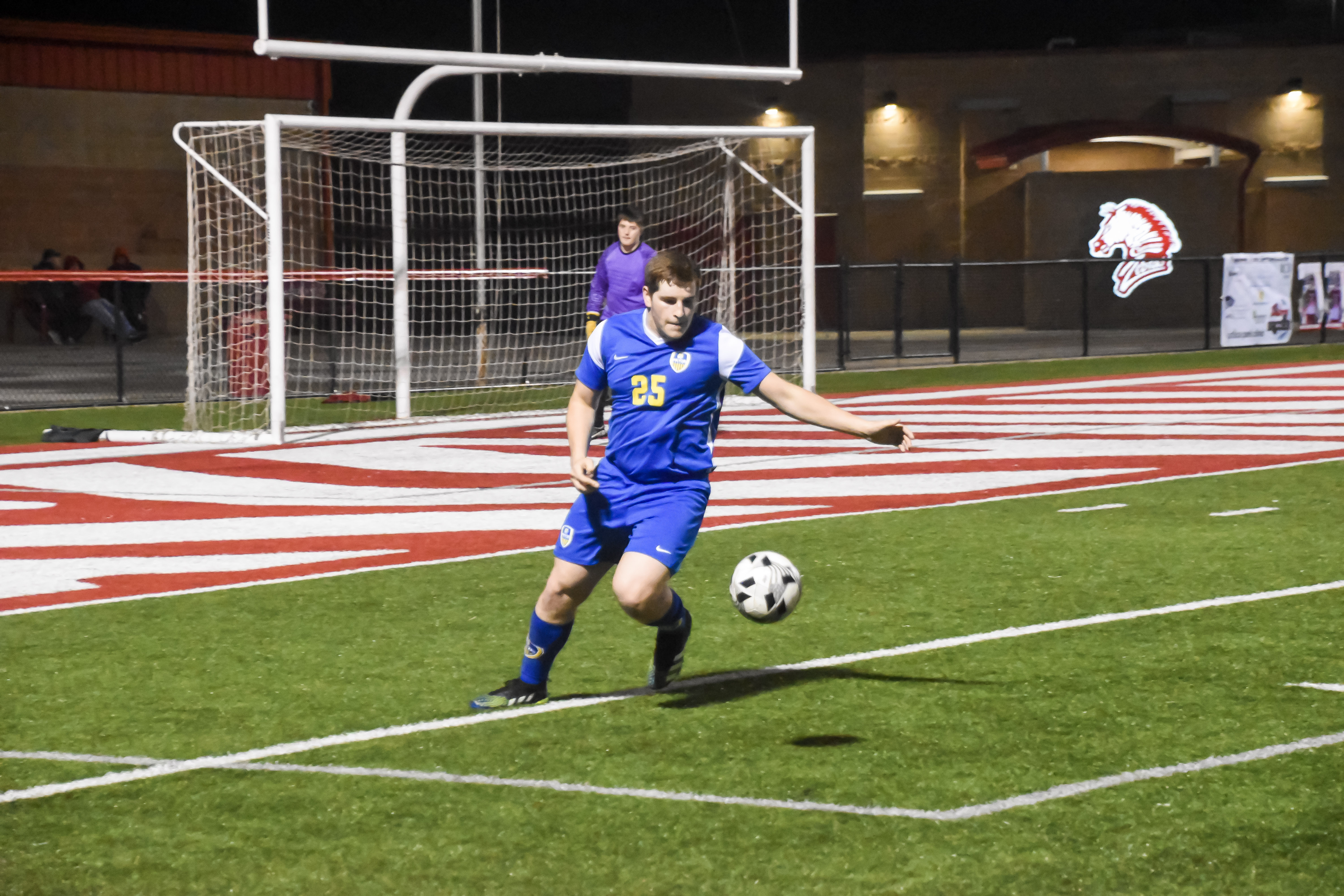 A pryor soccer athlete about to kick a soccer ball