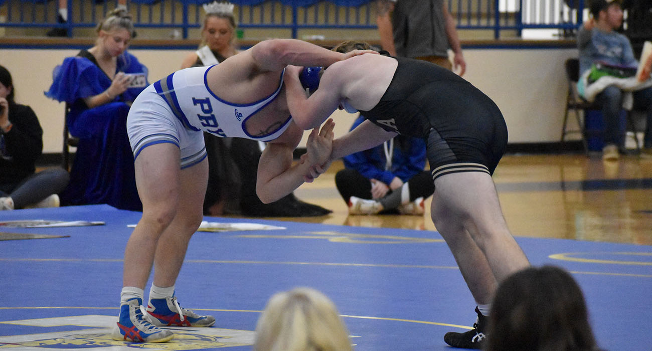 Two people holding each other in a wrestling match