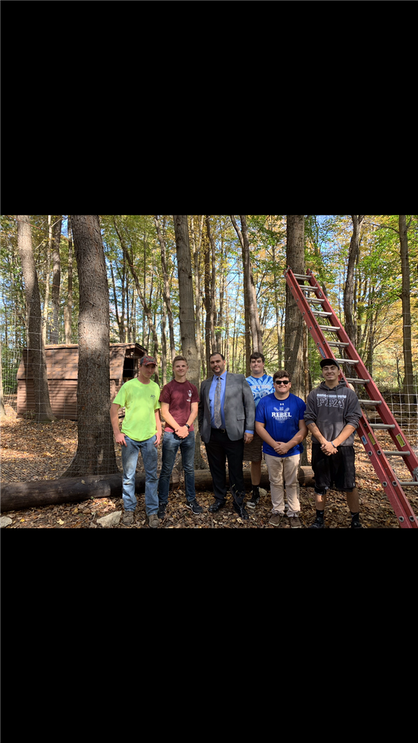 People posing for a picture in the middle of a forest.