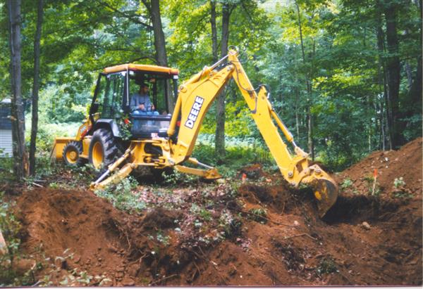 A guy using a bulldozer in the middle of a forest.