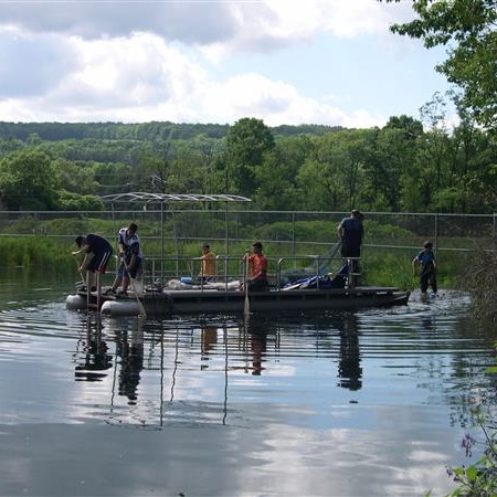 People on the boat in the middle of a lake.