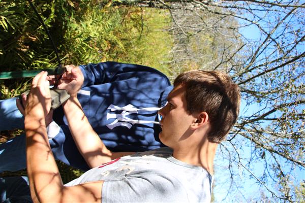 Two guys fixing their equipment in the middle of a forest.