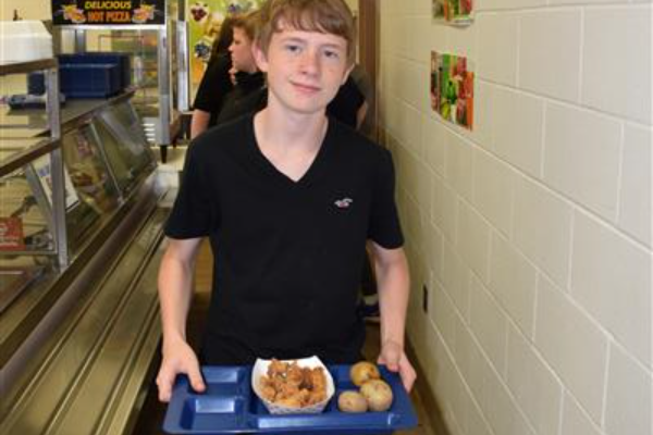 A boy holding a tray with his meal