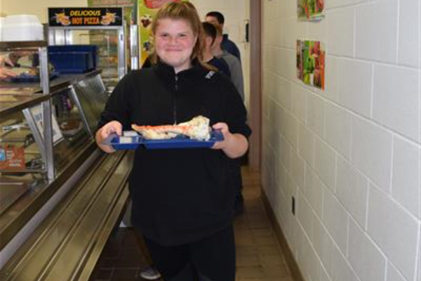 A girl holding a tray with her meal