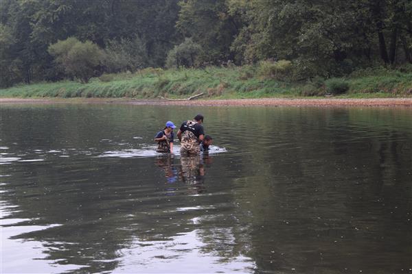 Three people on a lake trying to catch some fish.