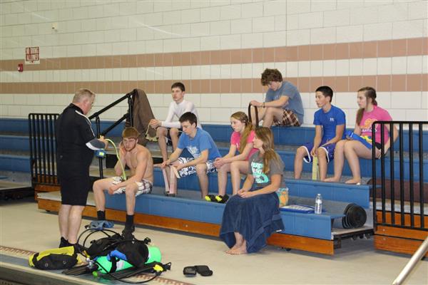 A guy coaching his students about SCUBA.