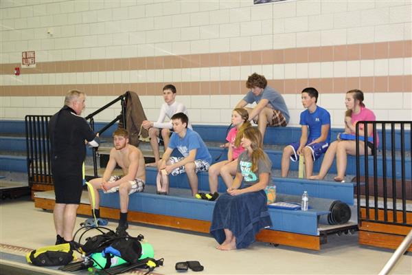 A guy coaching his students about SCUBA.