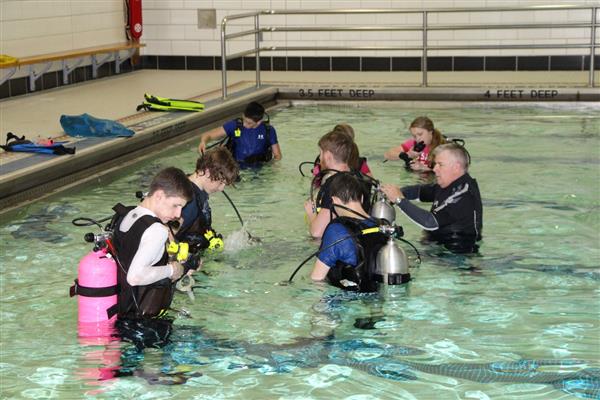 SCUBA Coach with his Students testing their equipment in the pool.