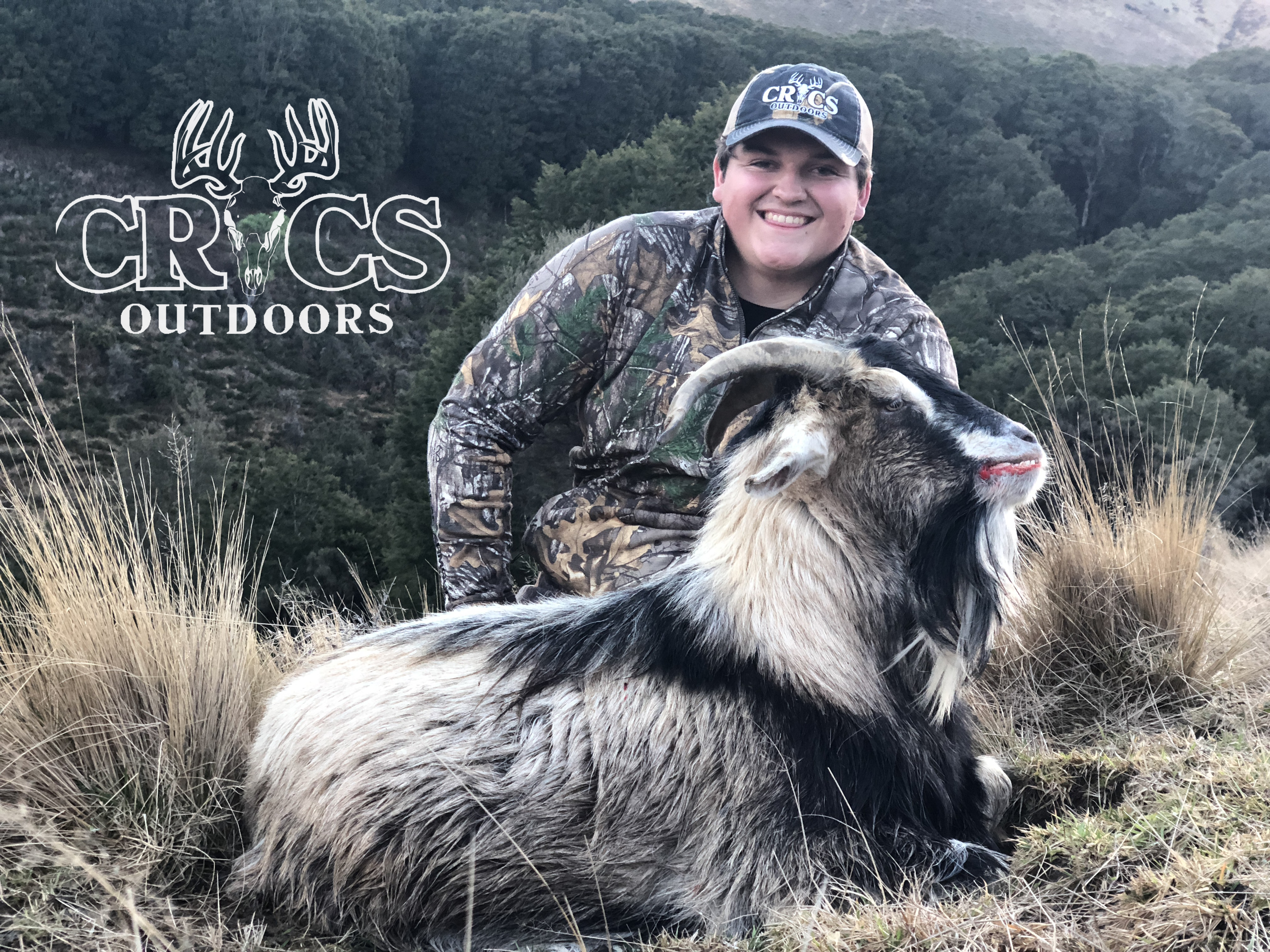 A boy posing with a goat.