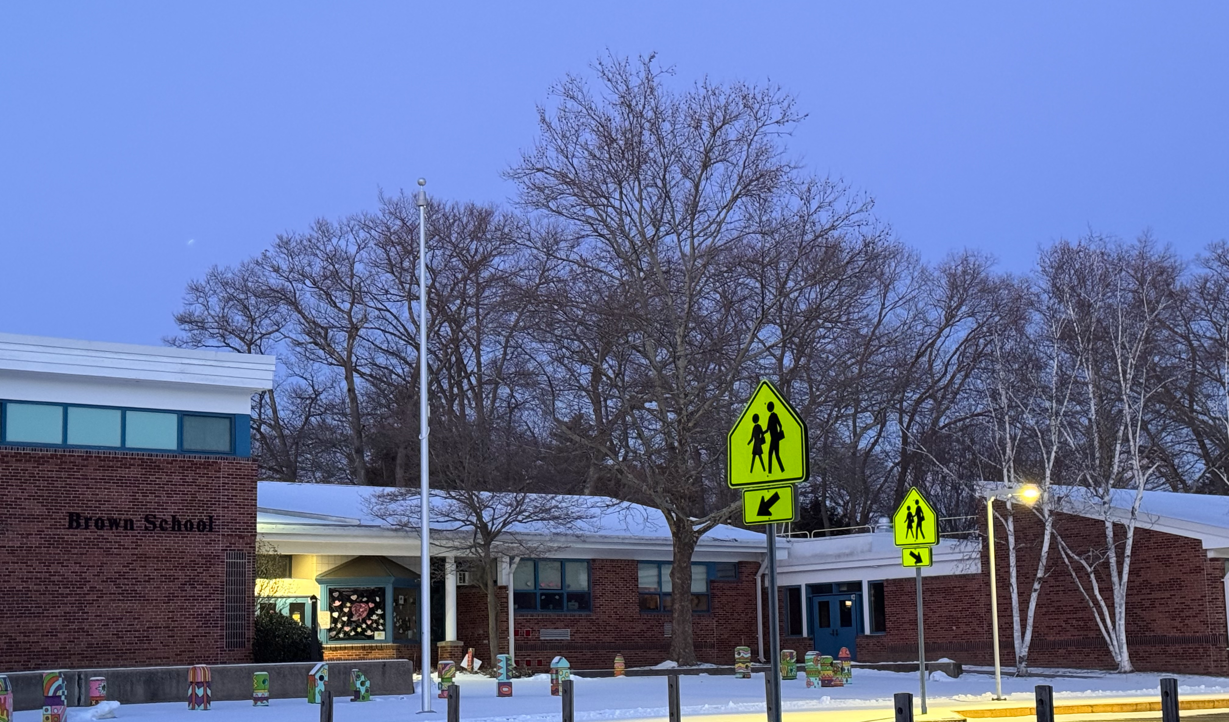 An image of the front of the building at dusk with snow on the ground.