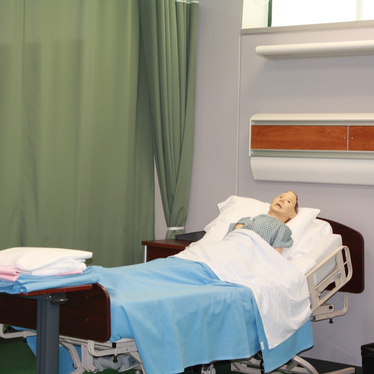 Mannequin patient in hospital bed for training