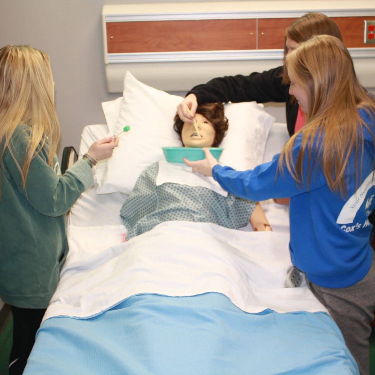 Students practicing treating a dummy patient