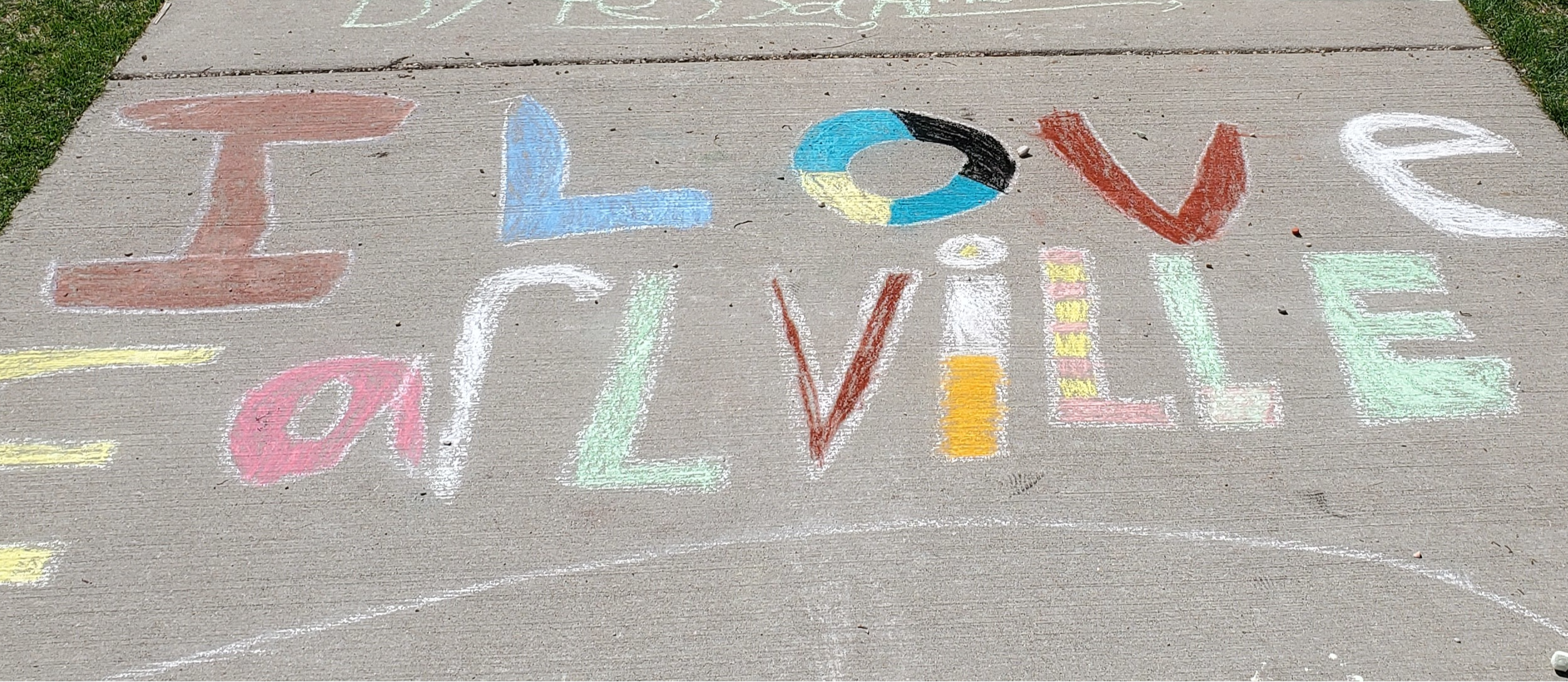 Students pose with a chalk drawing.