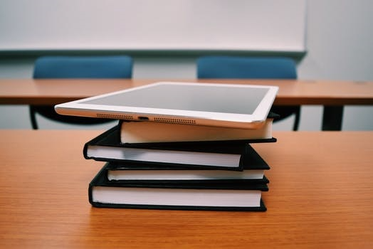 tablet stacked on top of books on desk