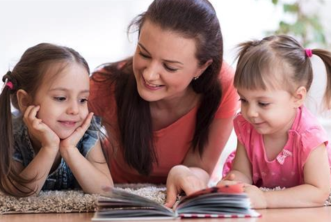 mom with her two daughters reading a book