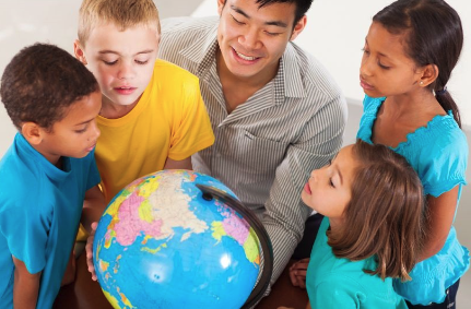 students and teacher watching a globe earth