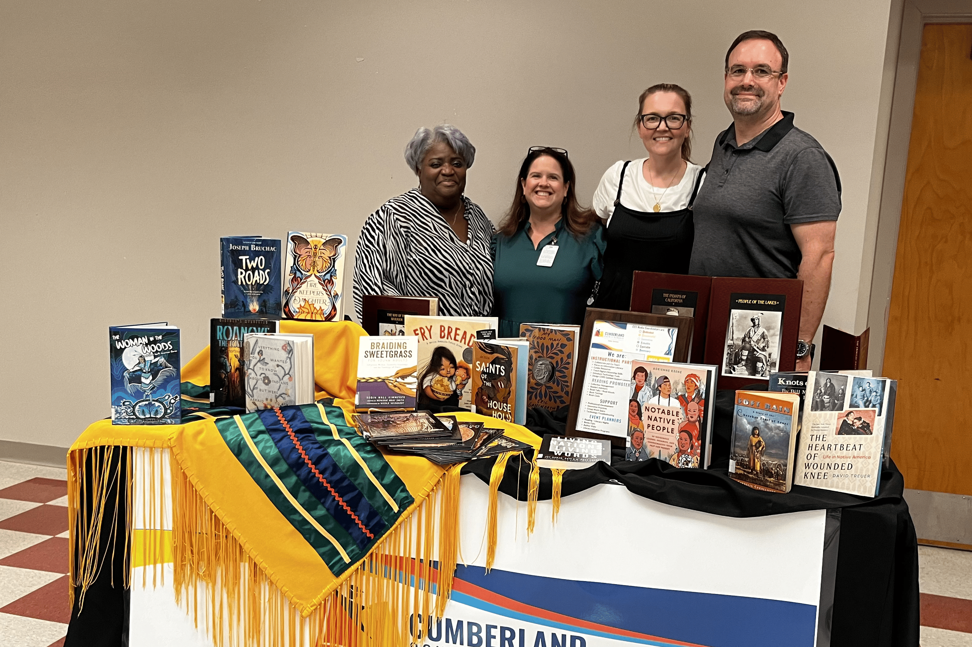 photo on a table display with books featuring Native American characters and/or authors from the CCS Media Centers.  Photo includes Jackie Colvin, Pamela Sands, Micheele Dooney, and Chris Fields