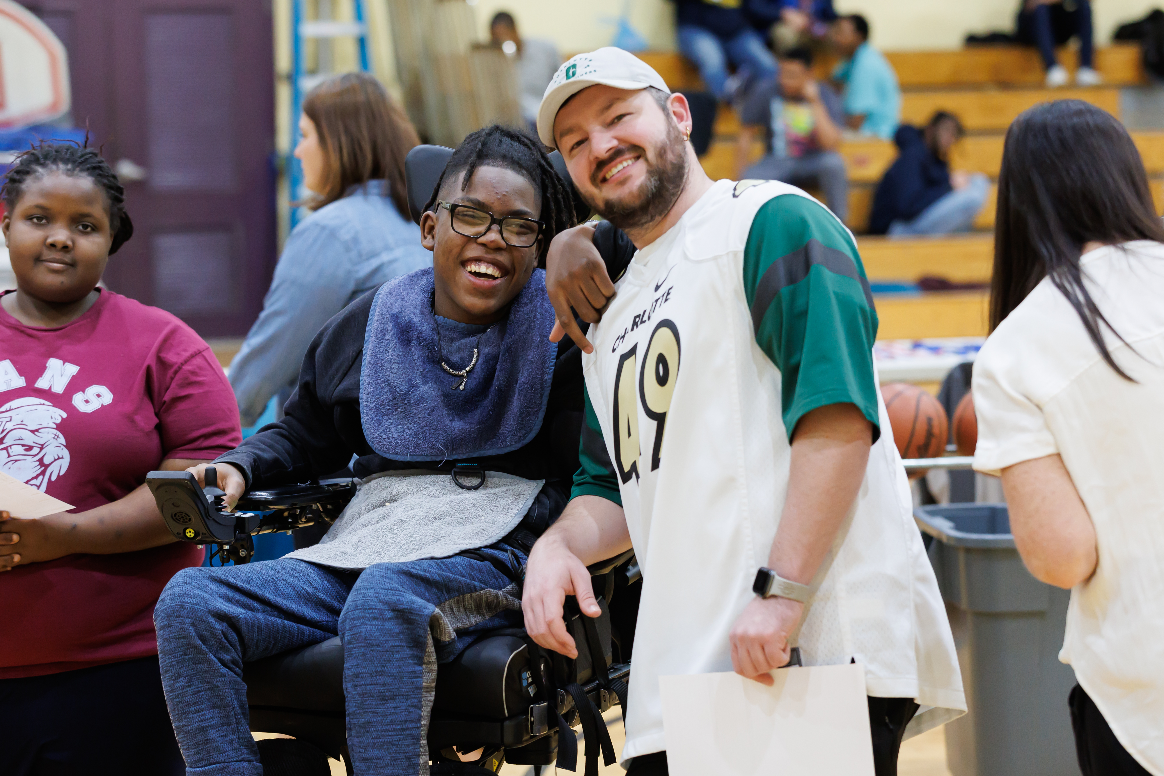 A volunteer helps an EC student during a free throw at an intramural basketball event