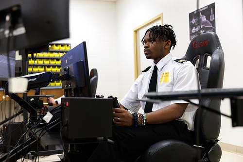 High school student in uniform focused on working at a computer