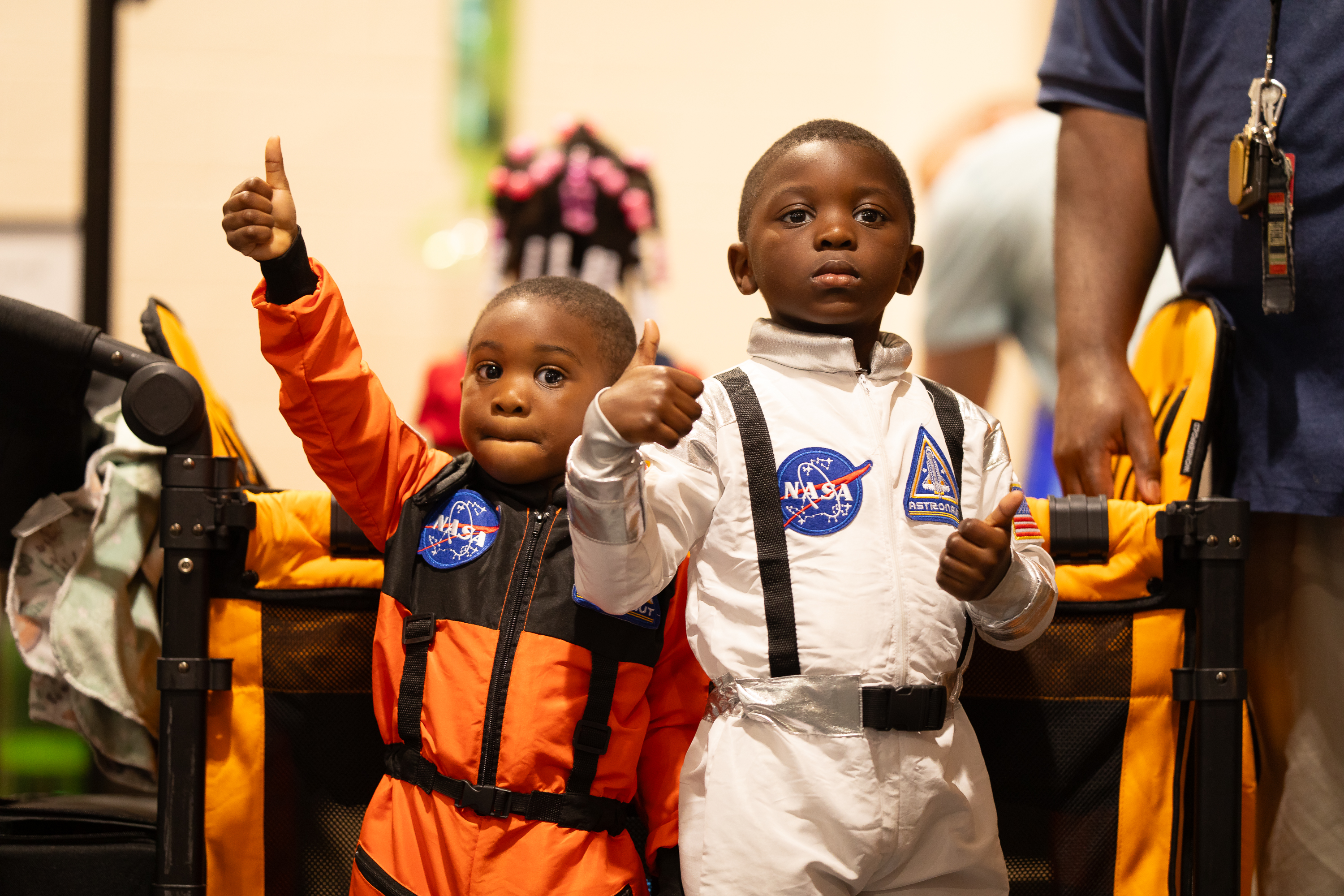 Two students dressed in NASA outfits, excited and ready to explore space themes.