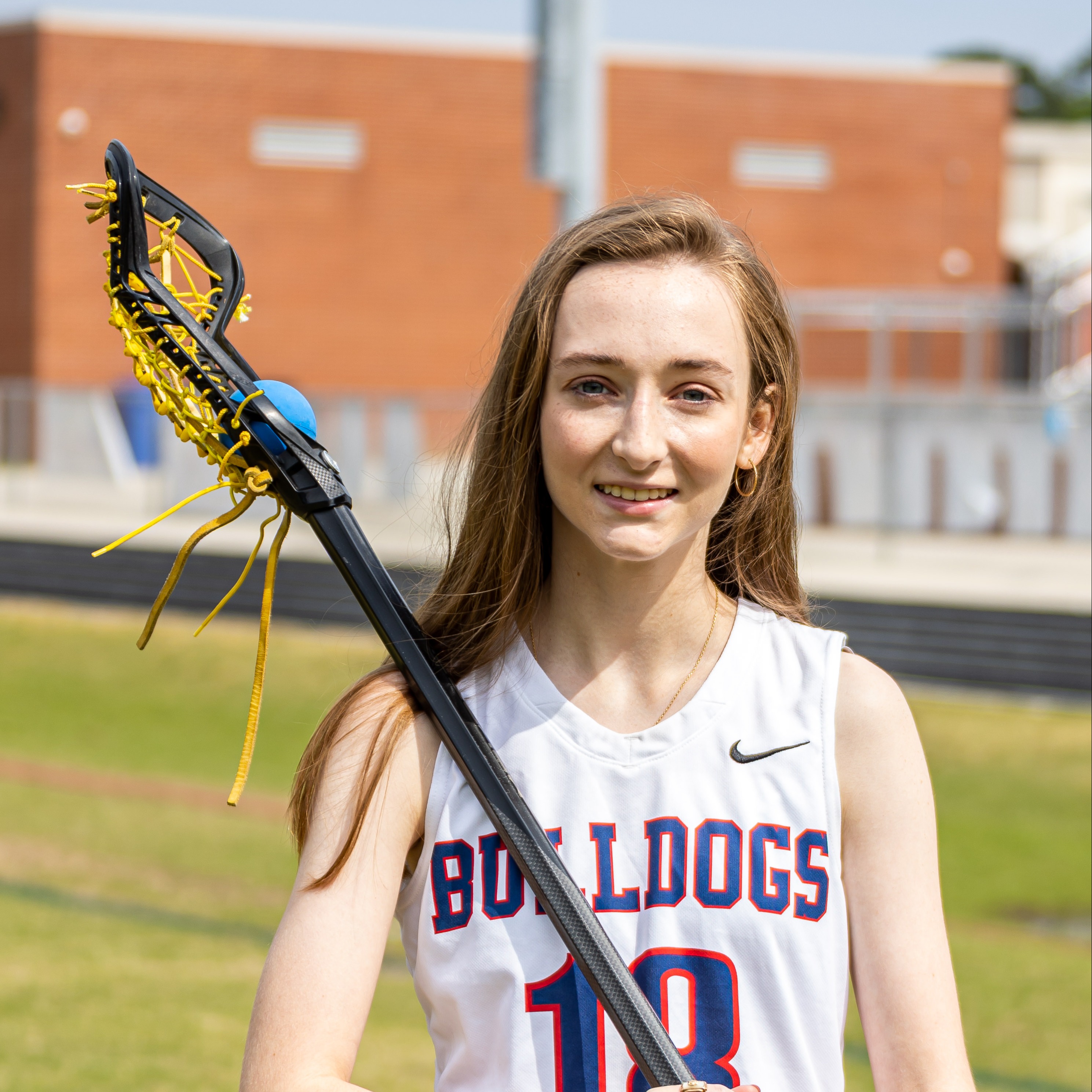 student with lacross stick