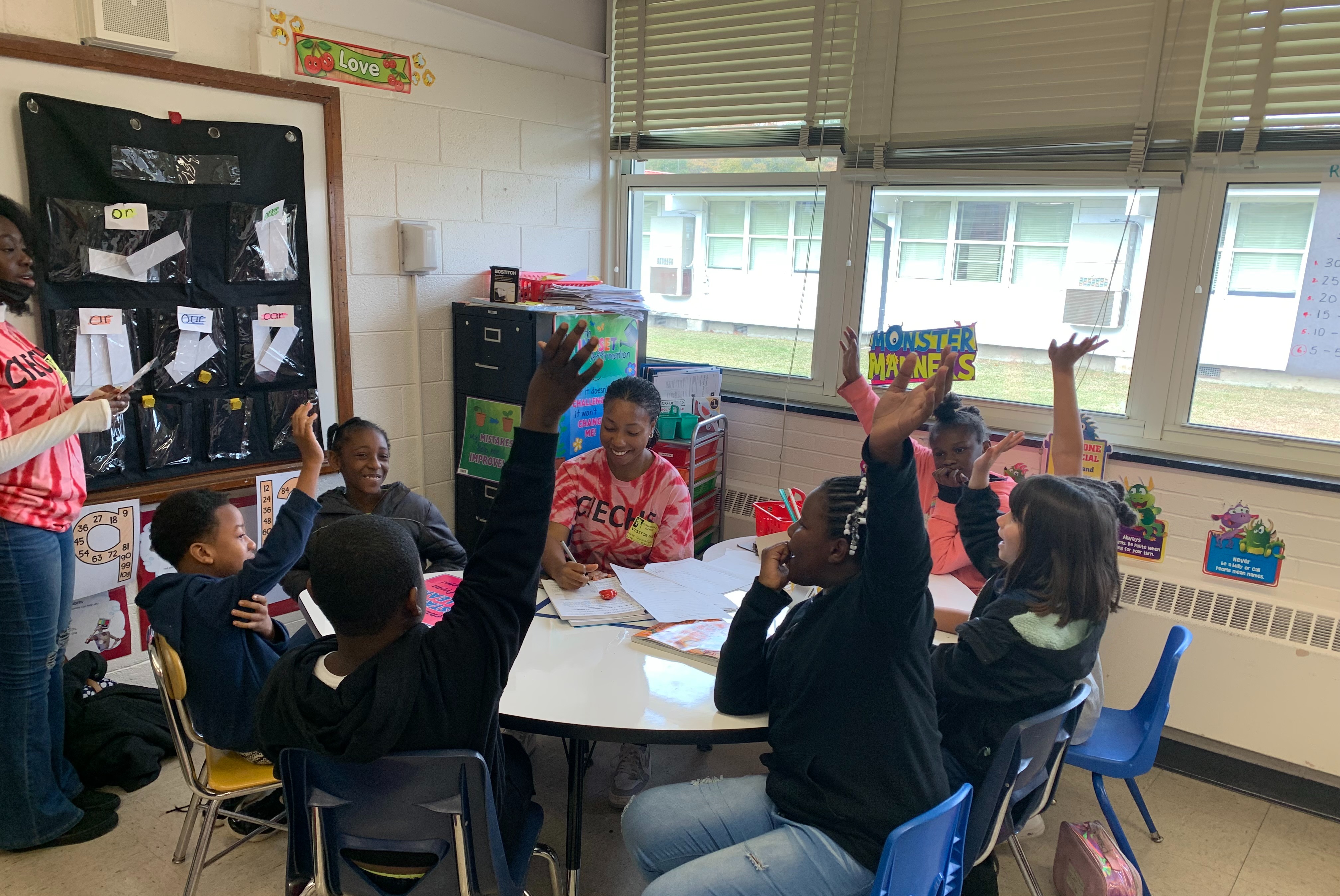 children and teacher at round table