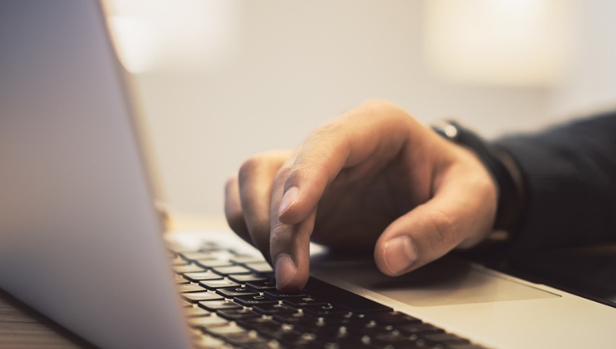 Hand on laptop keyboard