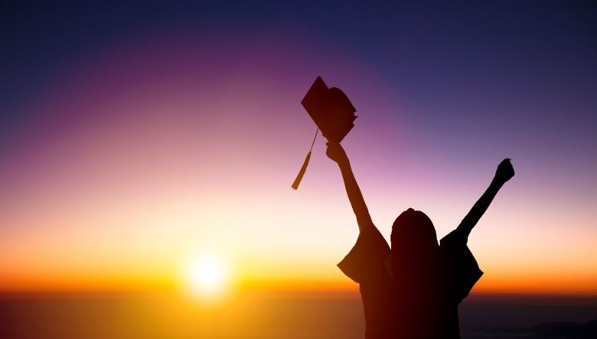 graduate with arms stretched