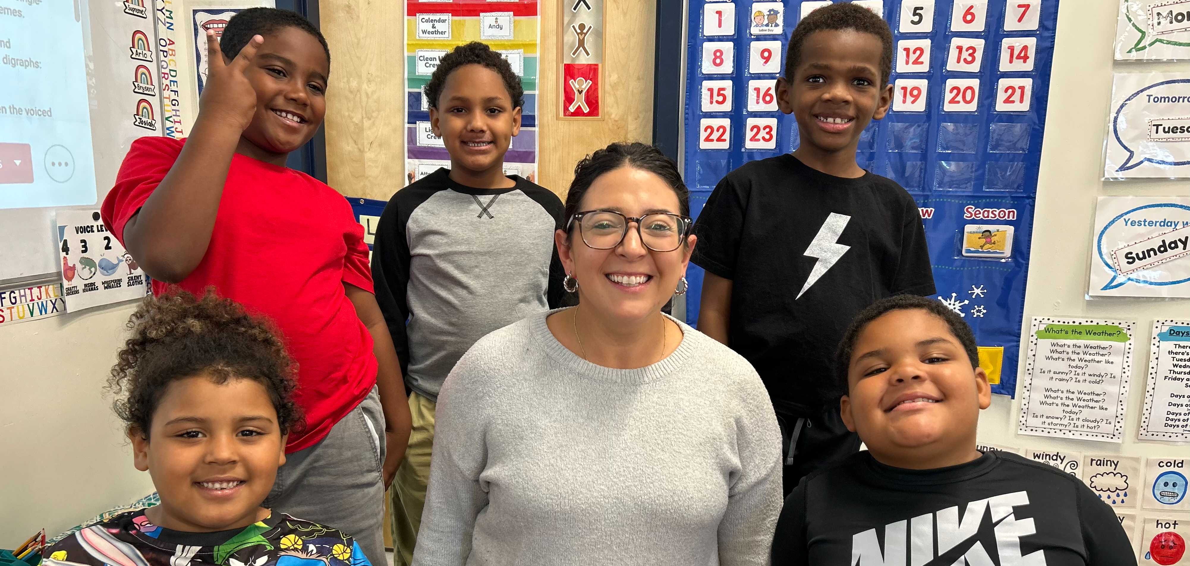 Five students and a teacher smile for a photo