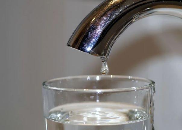 image of a faucet with water dripping into a cup