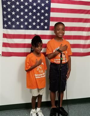 2 students saluting the flag