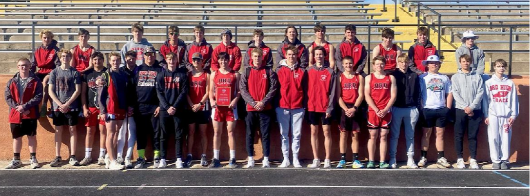 Photo of a red track field along with the school's logo