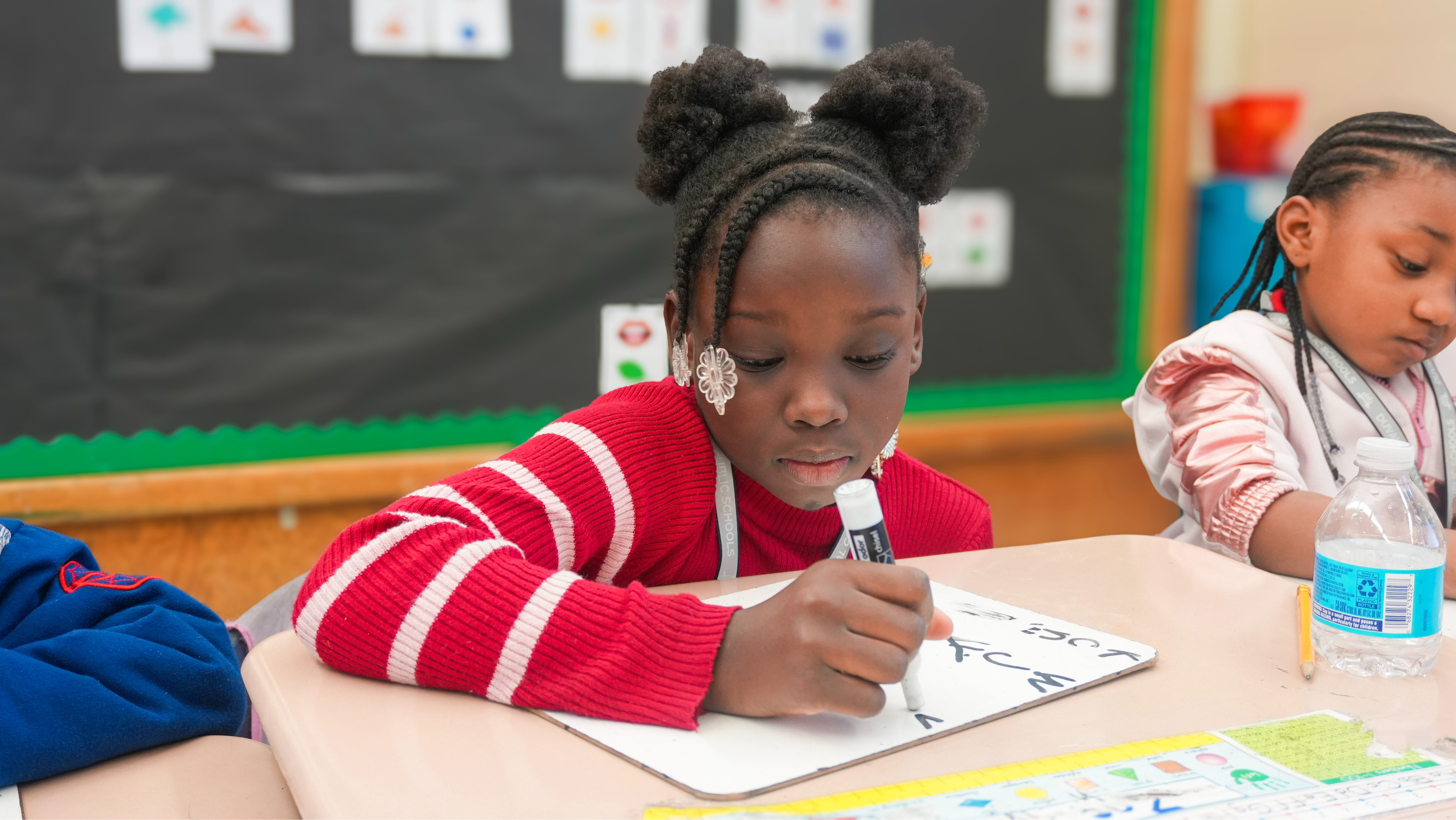 student writing on a white board