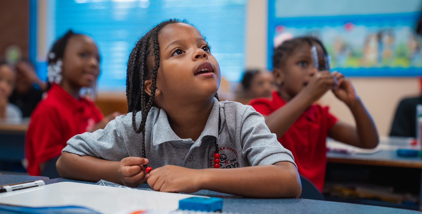 student at his desk listening to the teacher