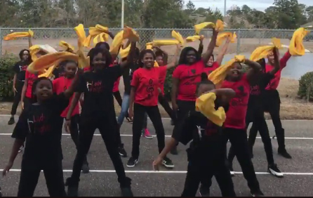 Students dancing with yellow flag