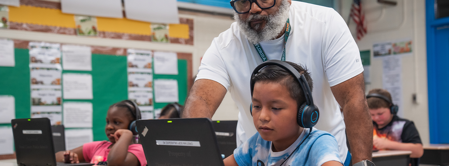 Teacher helping a student at a computer