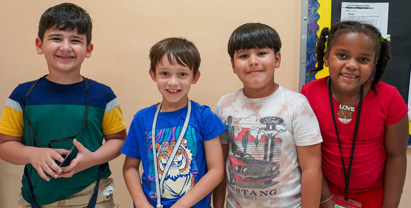 4 students smiling at the camera 