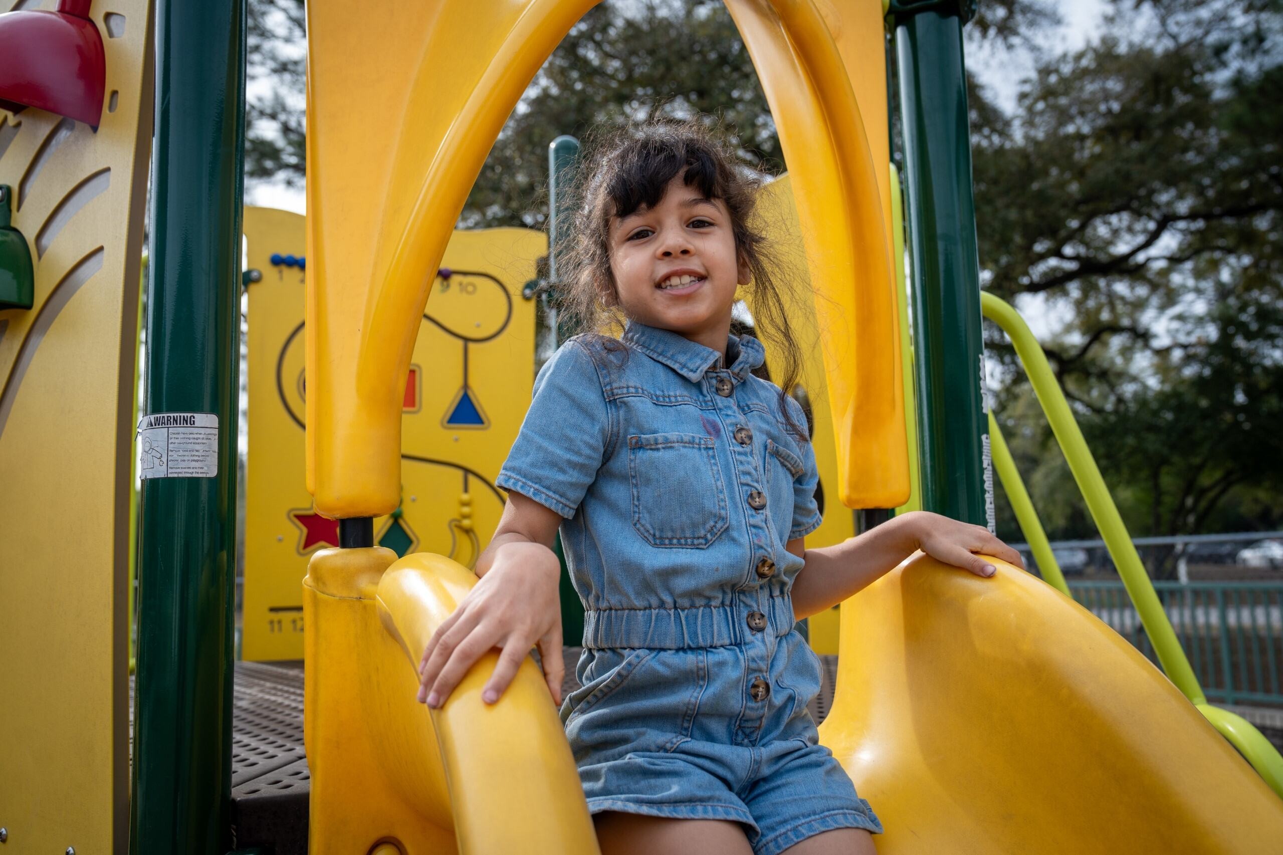 Student smiling at the camera on the playground