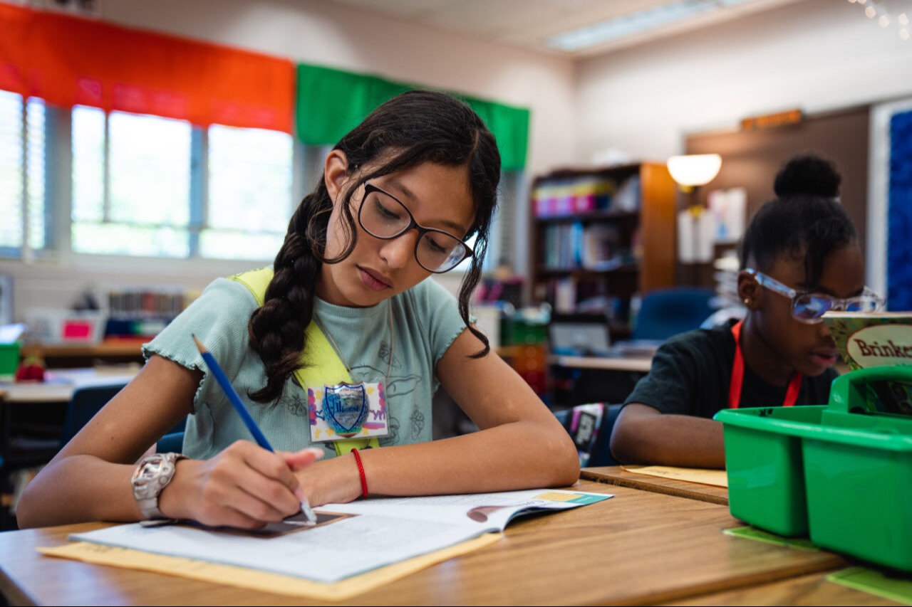 A student doing work with her safety patrol belt on