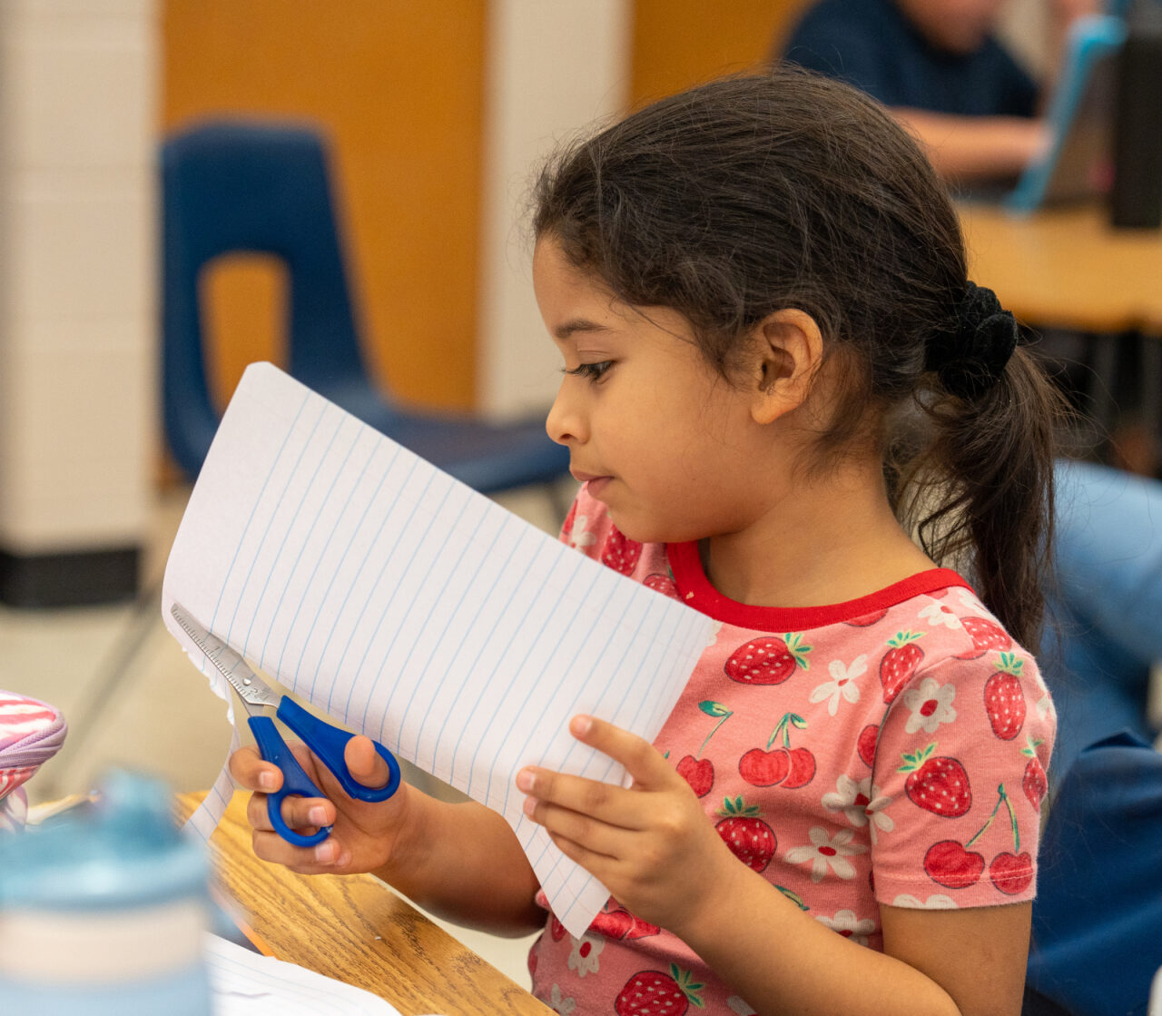 Student cutting paper