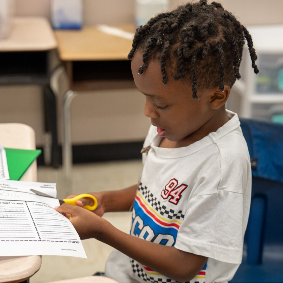 Student cutting a paper