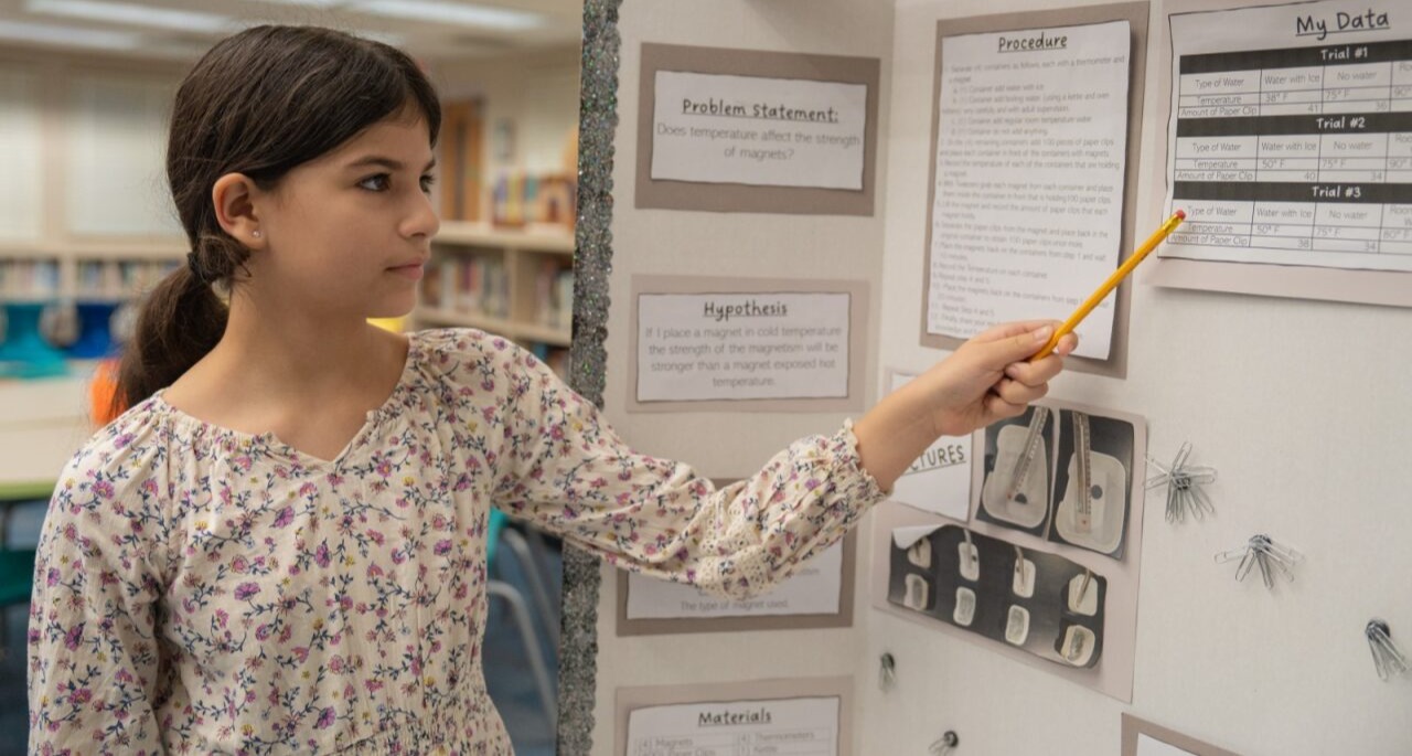 Student pointing at her science project
