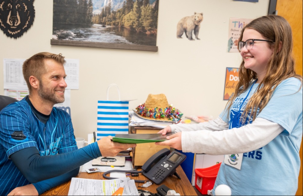 Teacher of Tomorrow student delivering files to a teacher at Crown Point.