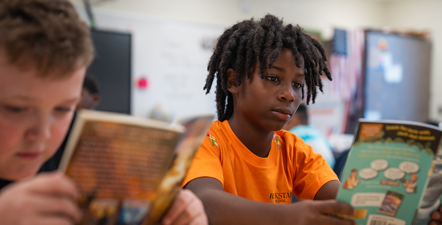 kid reading a book in class