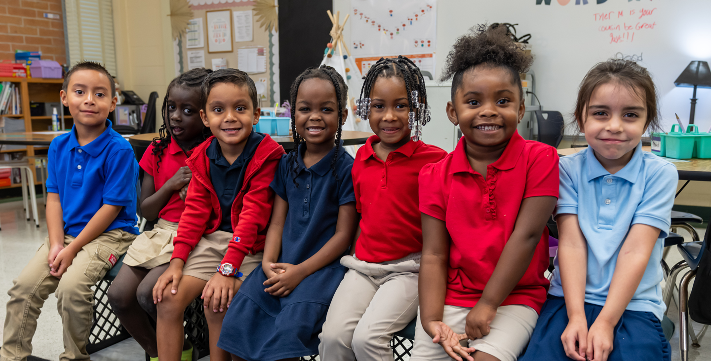 group of smiling students in a classroom