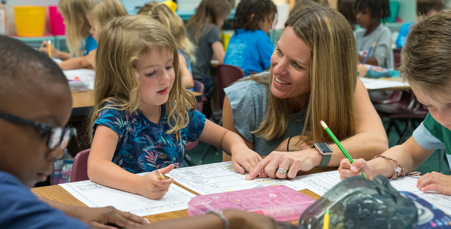 Teacher helping a student with her assignment